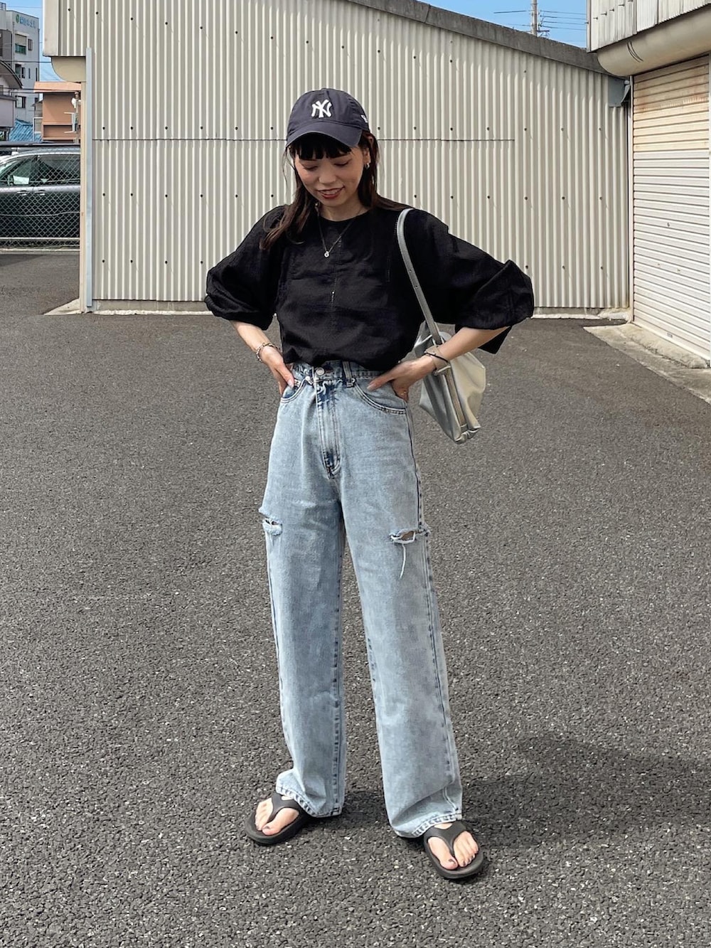 ブラック系のシャツ/ブラウス、ブルー系のデニムパンツ、シルバー系のショルダーバッグを着用したレディースの夏コーディネートの2枚目の写真