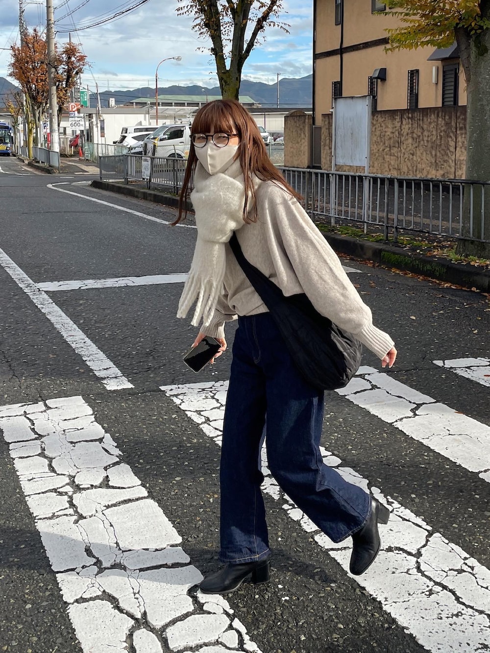 ベージュ系のニット/セーター、ブルー系のデニムパンツを着用したレディースの冬コーディネートの2枚目の写真