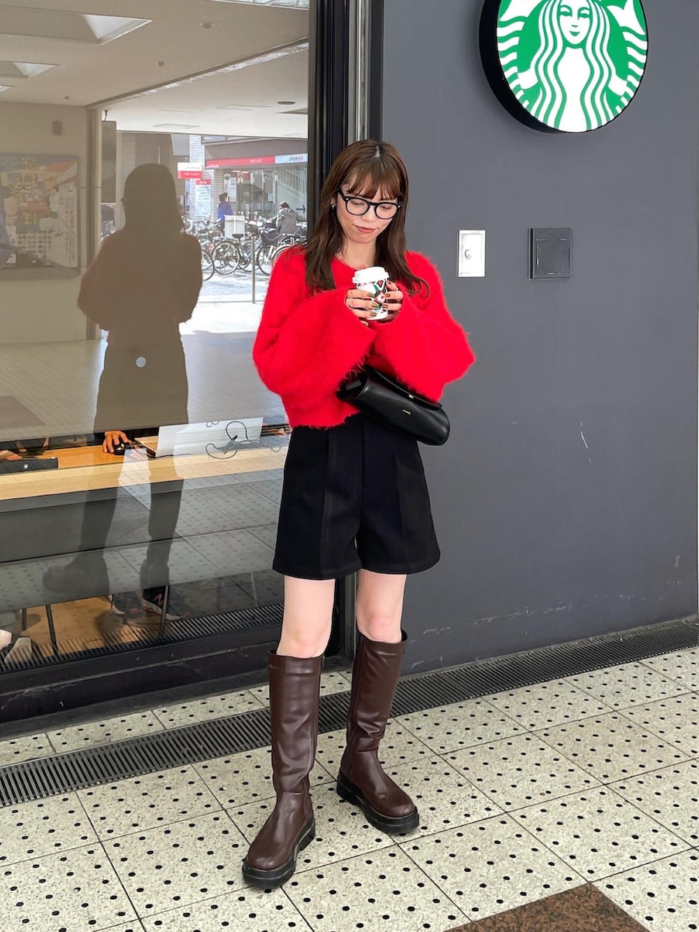 レッド系のニット/セーター、ブラック系のその他パンツ、ブラウン系のブーツを着用したレディースの秋コーディネートの2枚目の写真