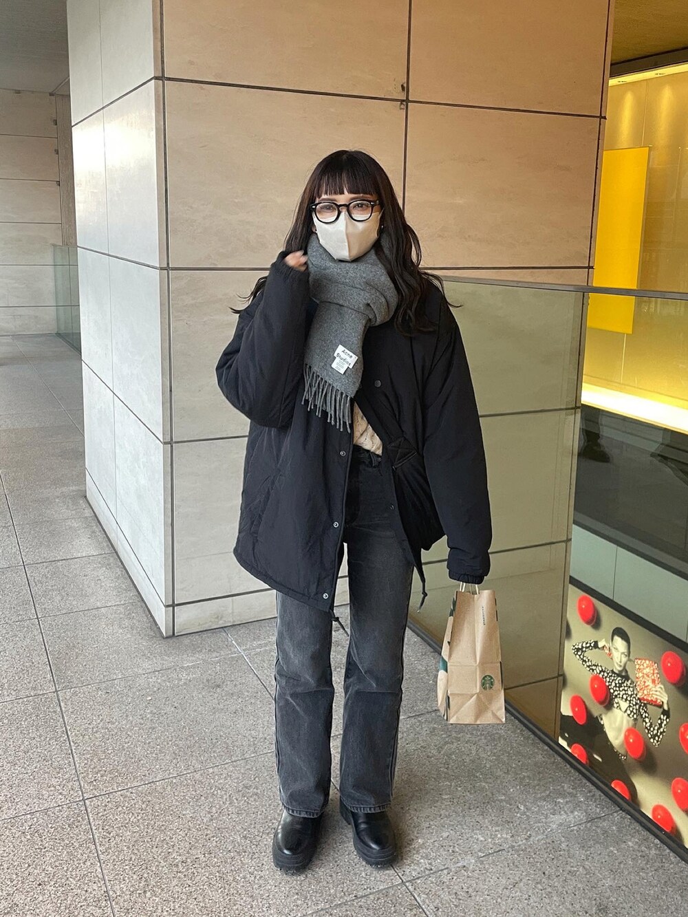 ブラック系のブルゾン、ブラック系のデニムパンツ、ブラック系のショルダーバッグを着用したレディースの冬コーディネートの3枚目の写真