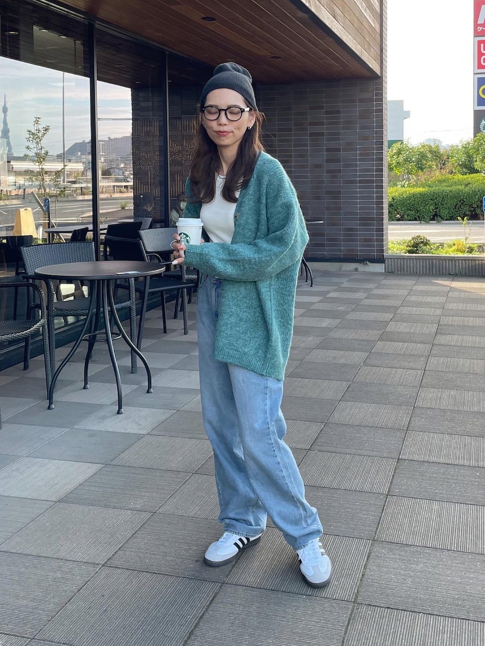 グリーン系のカーディガン/ボレロ、ホワイト系のスニーカーを着用したレディースの秋コーディネートの4枚目の写真