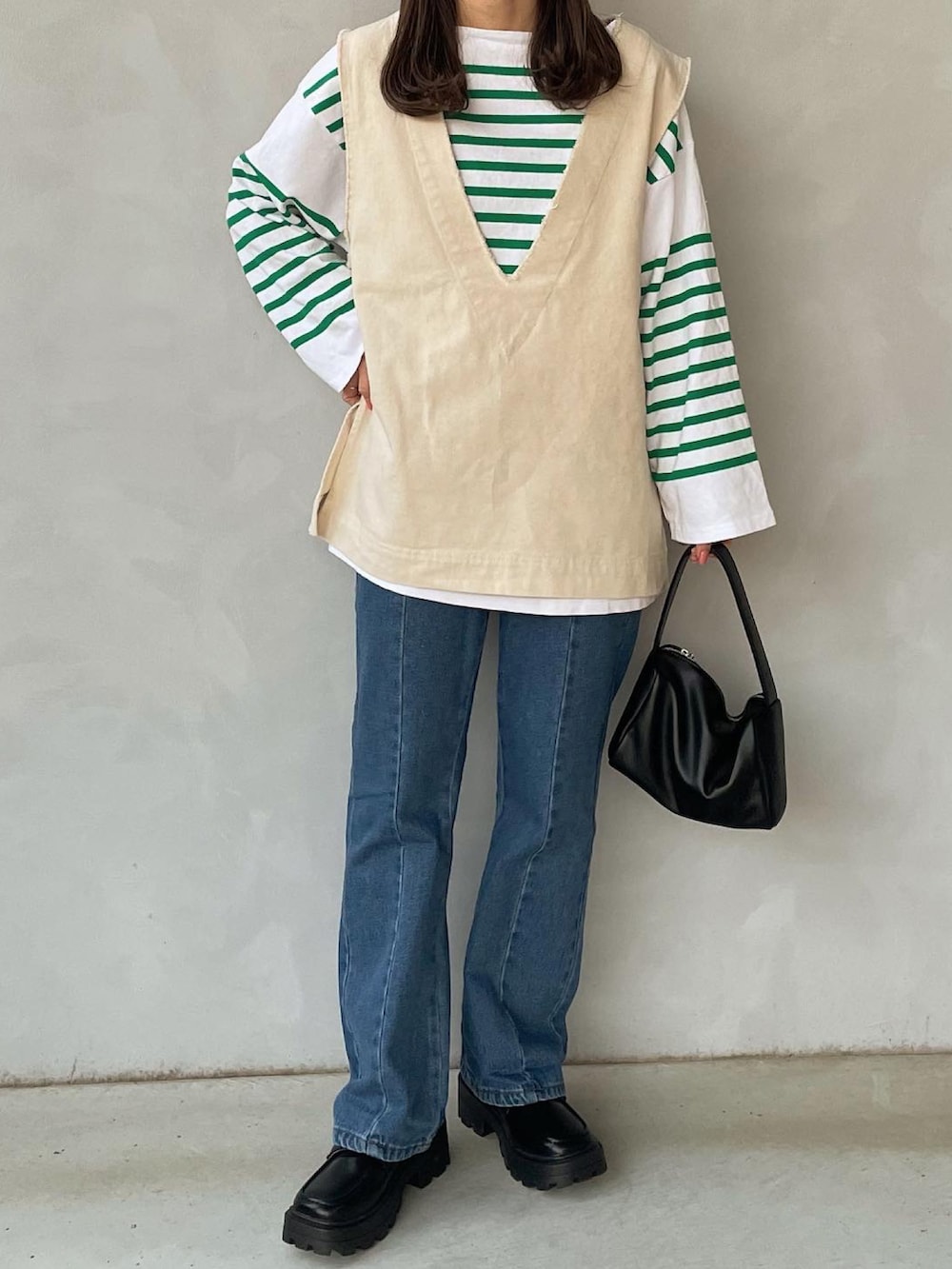 グリーン系のTシャツ/カットソー、ホワイト系のベスト、ブルー系のデニムパンツを着用したレディースの春コーディネートの2枚目の写真