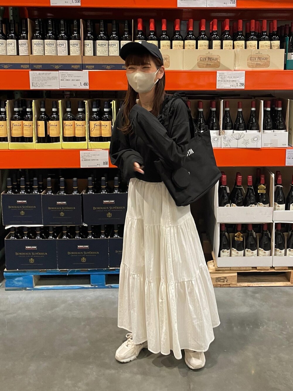 ホワイト系のスカート、ブラック系のトートバッグ、ブラック系のキャップを着用したレディースの夏コーディネートの4枚目の写真