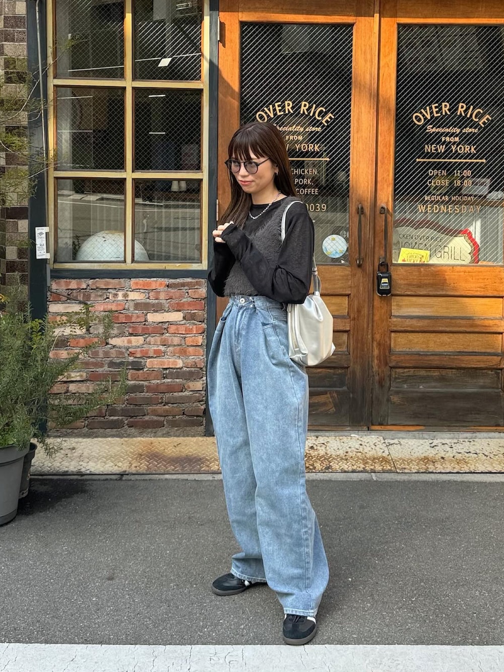 ブルー系のデニムパンツ、ホワイト系のショルダーバッグ、ブラック系のスニーカーを着用したレディースの冬コーディネートの4枚目の写真