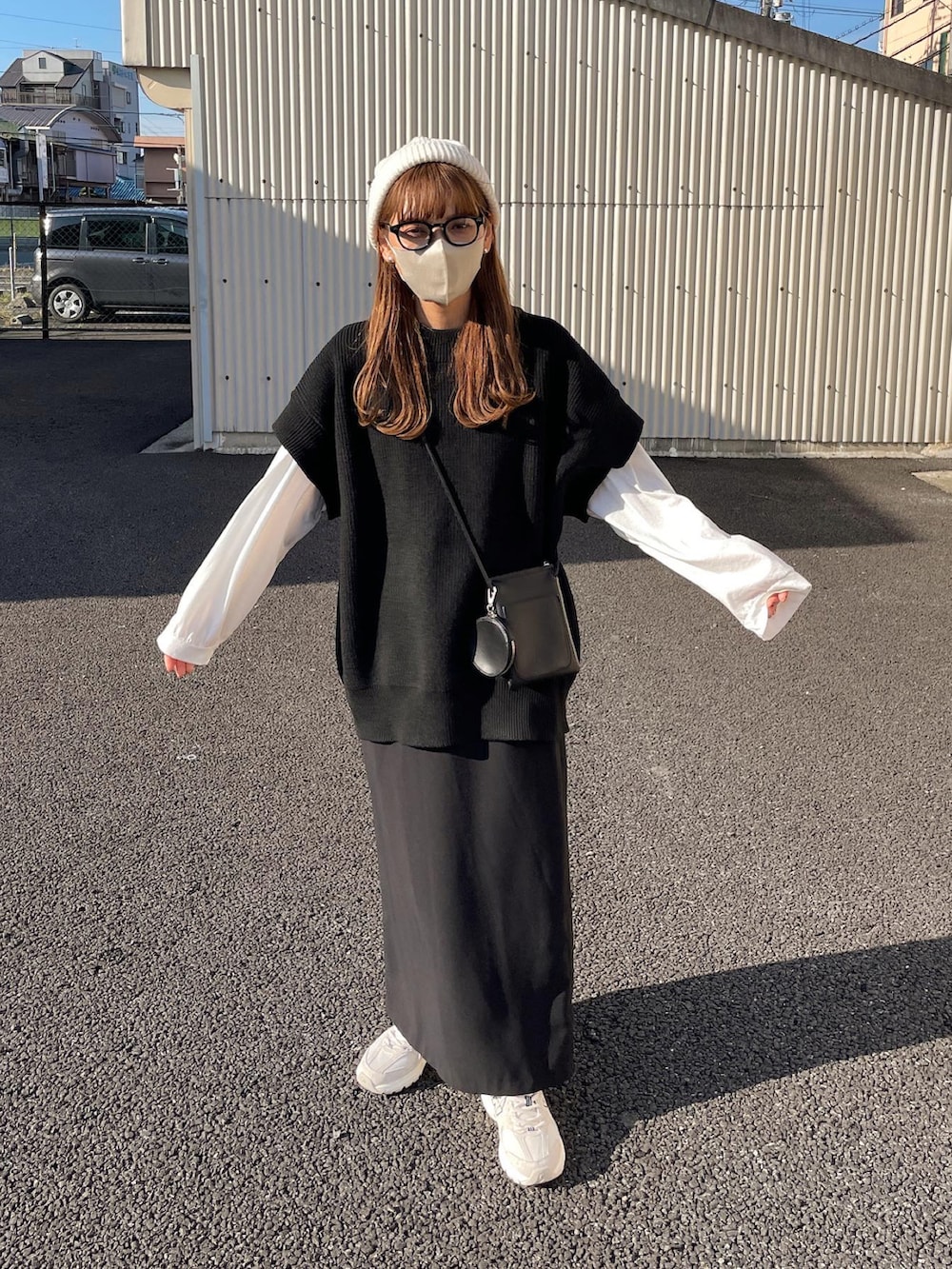 ブラック系のベスト、ホワイト系のTシャツ/カットソー、ブラック系のスカートを着用したレディースの秋コーディネートの2枚目の写真