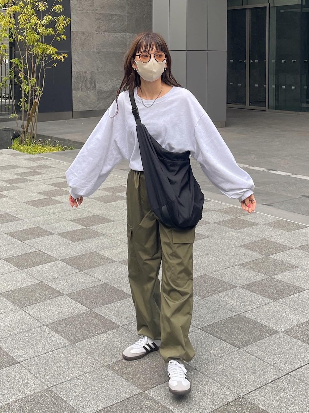 ホワイト系のTシャツ/カットソー、グリーン系のカーゴパンツ、ブラック系のショルダーバッグを着用したレディースの春コーディネートの3枚目の写真