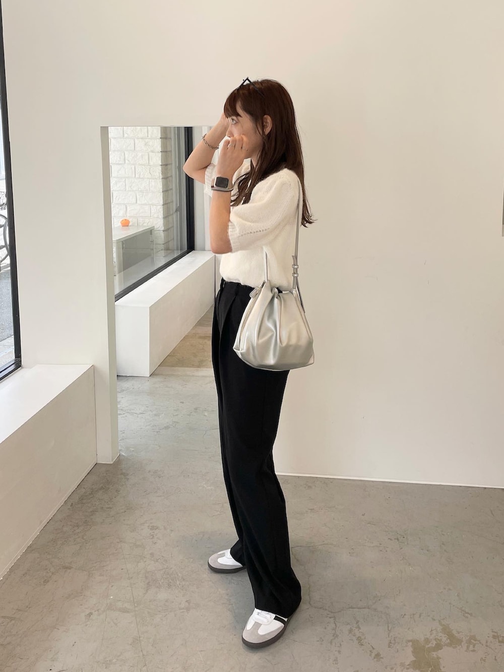 ホワイト系のニット/セーター、シルバー系のショルダーバッグ、ホワイト系のスニーカーを着用したレディースの秋コーディネートの4枚目の写真