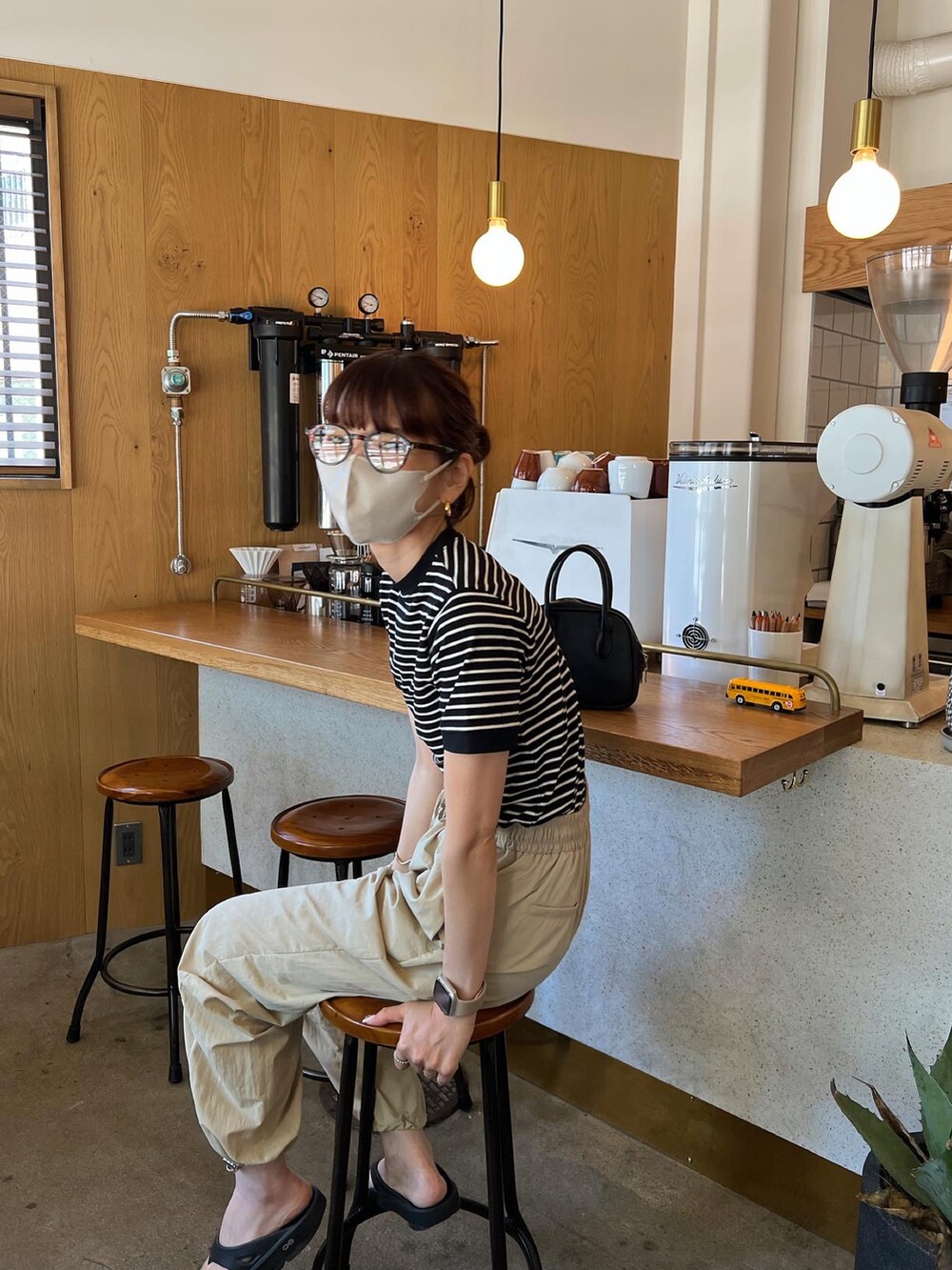 ブラック系のTシャツ/カットソー、ピンク系のカーゴパンツ、ブラック系のサンダルを着用したレディースの夏コーディネートの3枚目の写真