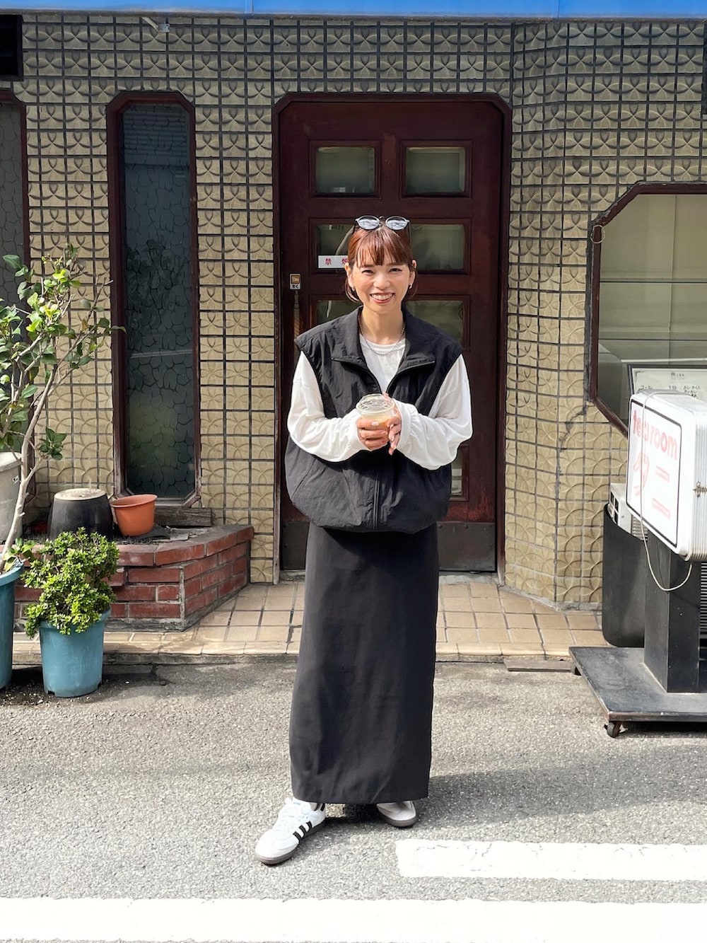 ブラック系のベスト、ホワイト系のTシャツ/カットソー、ブラック系のスカートを着用したレディースの秋コーディネートの5枚目の写真