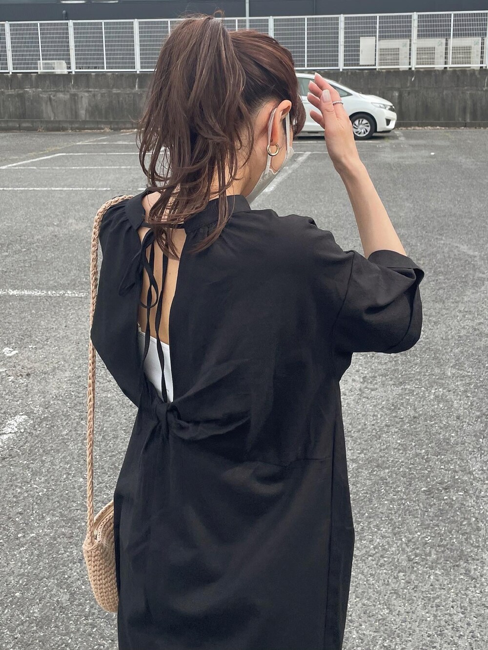 ブラック系のワンピース、ブルー系のデニムパンツ、ベージュ系のショルダーバッグを着用したレディースの夏コーディネートの2枚目の写真