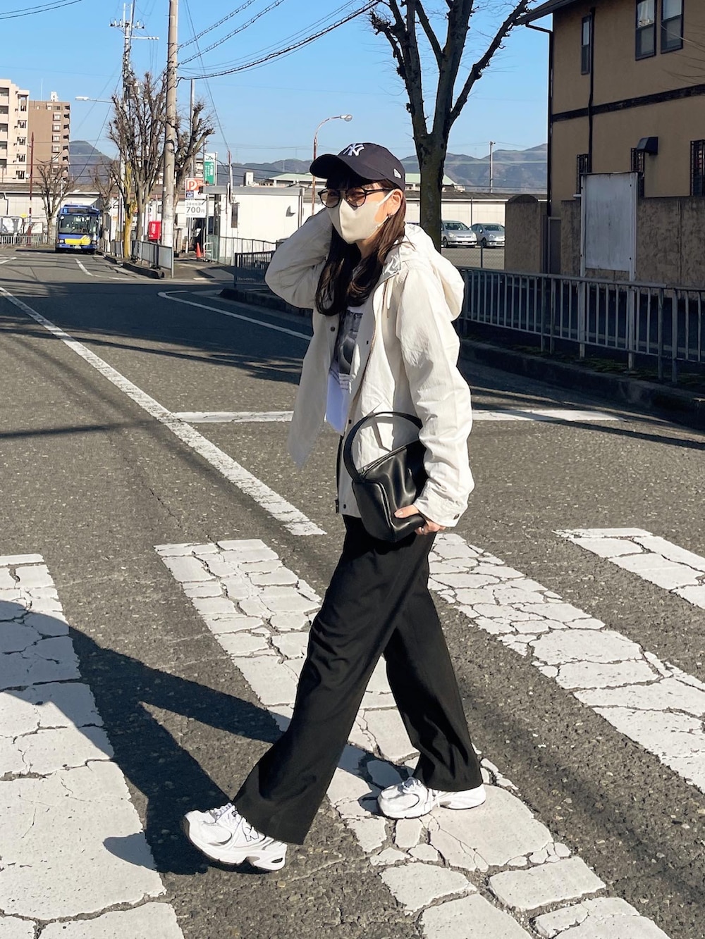 ホワイト系のマウンテンパーカー、ブルー系のキャップを着用したレディースの春コーディネートの2枚目の写真