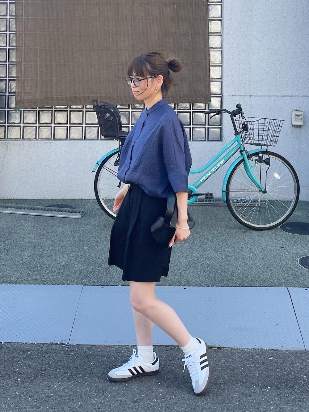 ブルー系のシャツ/ブラウス、ブラック系のその他パンツ、ホワイト系のスニーカーを着用したレディースの春コーディネートの2枚目の写真