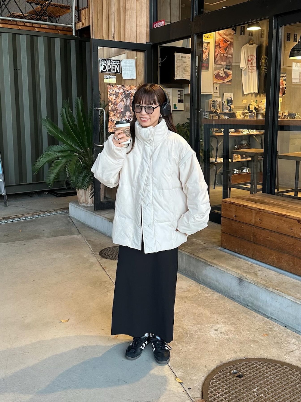 ホワイト系のダウンジャケット/コート、ブラック系のスカート、ブラック系のスニーカーを着用したレディースの冬コーディネートの3枚目の写真