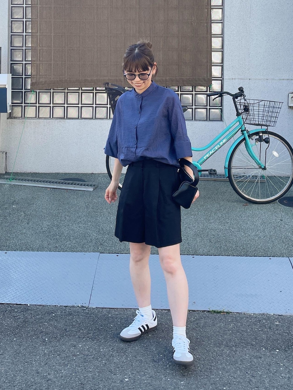 ブルー系のシャツ/ブラウス、ブラック系のその他パンツ、ホワイト系のスニーカーを着用したレディースの春コーディネートの4枚目の写真