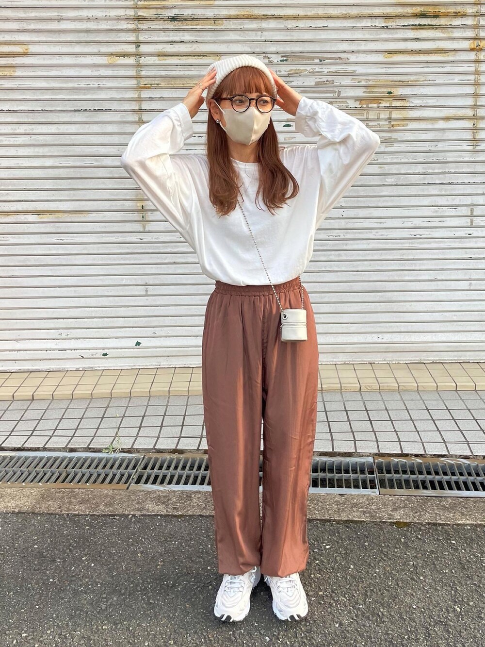 ブラウン系のその他パンツ、ホワイト系のショルダーバッグ、ベージュ系のスニーカーを着用したレディースの秋コーディネートの2枚目の写真