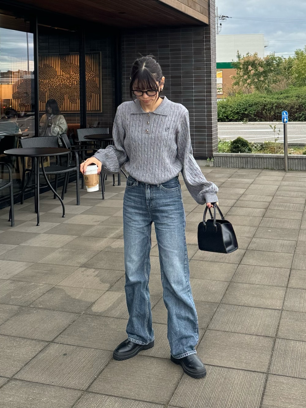 グレー系のニット/セーター、ブルー系のデニムパンツを着用したレディースの秋コーディネートの3枚目の写真