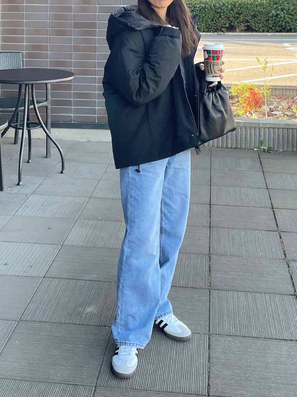 ブラック系のダウンジャケット/コート、ホワイト系のスニーカー、ブラック系のニットキャップ/ビーニーを着用したレディースの冬コーディネートの4枚目の写真