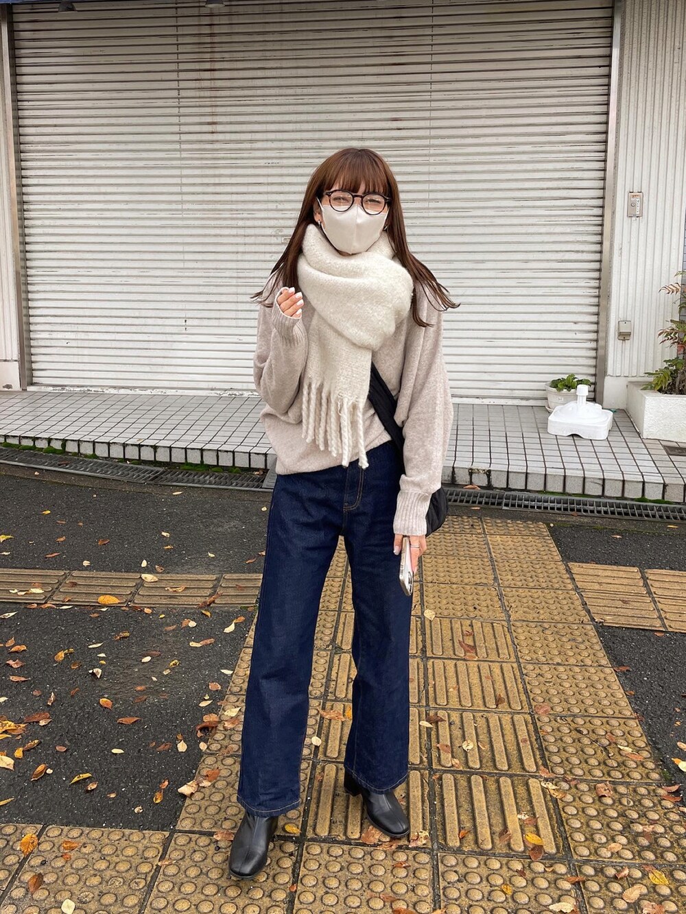 ベージュ系のニット/セーター、ブルー系のデニムパンツを着用したレディースの冬コーディネートの4枚目の写真