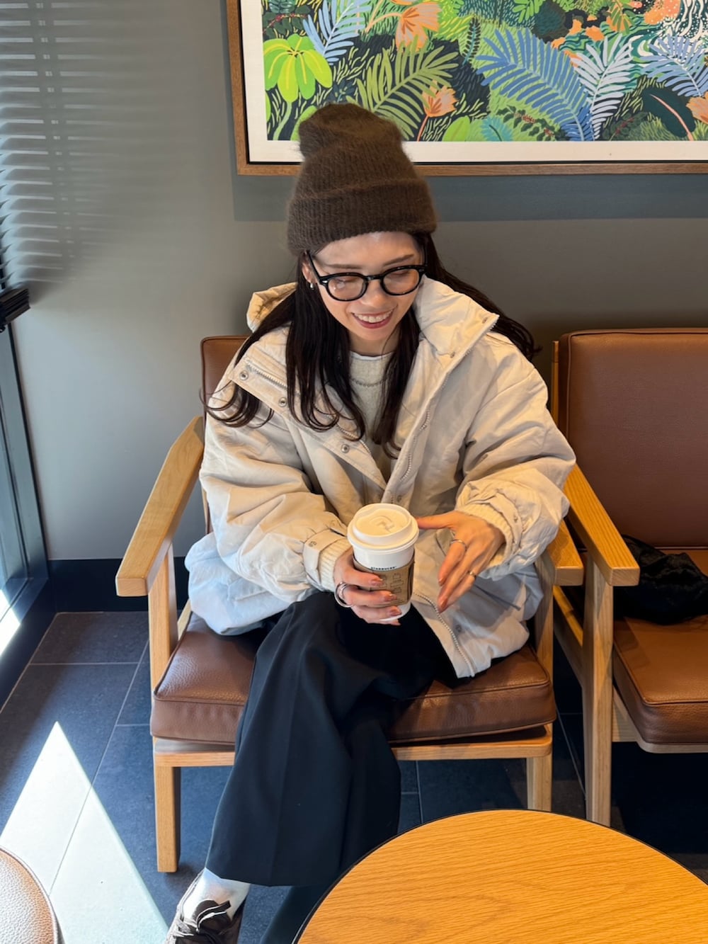 ホワイト系のダウンジャケット/コート、ホワイト系のニット/セーター、ブラック系のショルダーバッグを着用したレディースの冬コーディネートの2枚目の写真