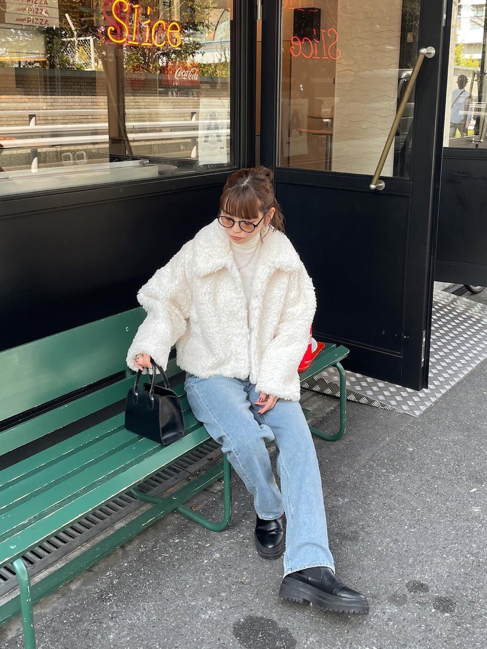 ホワイト系のその他アウター、ブルー系のデニムパンツ、ブラック系のショルダーバッグを着用したレディースの冬コーディネートの4枚目の写真