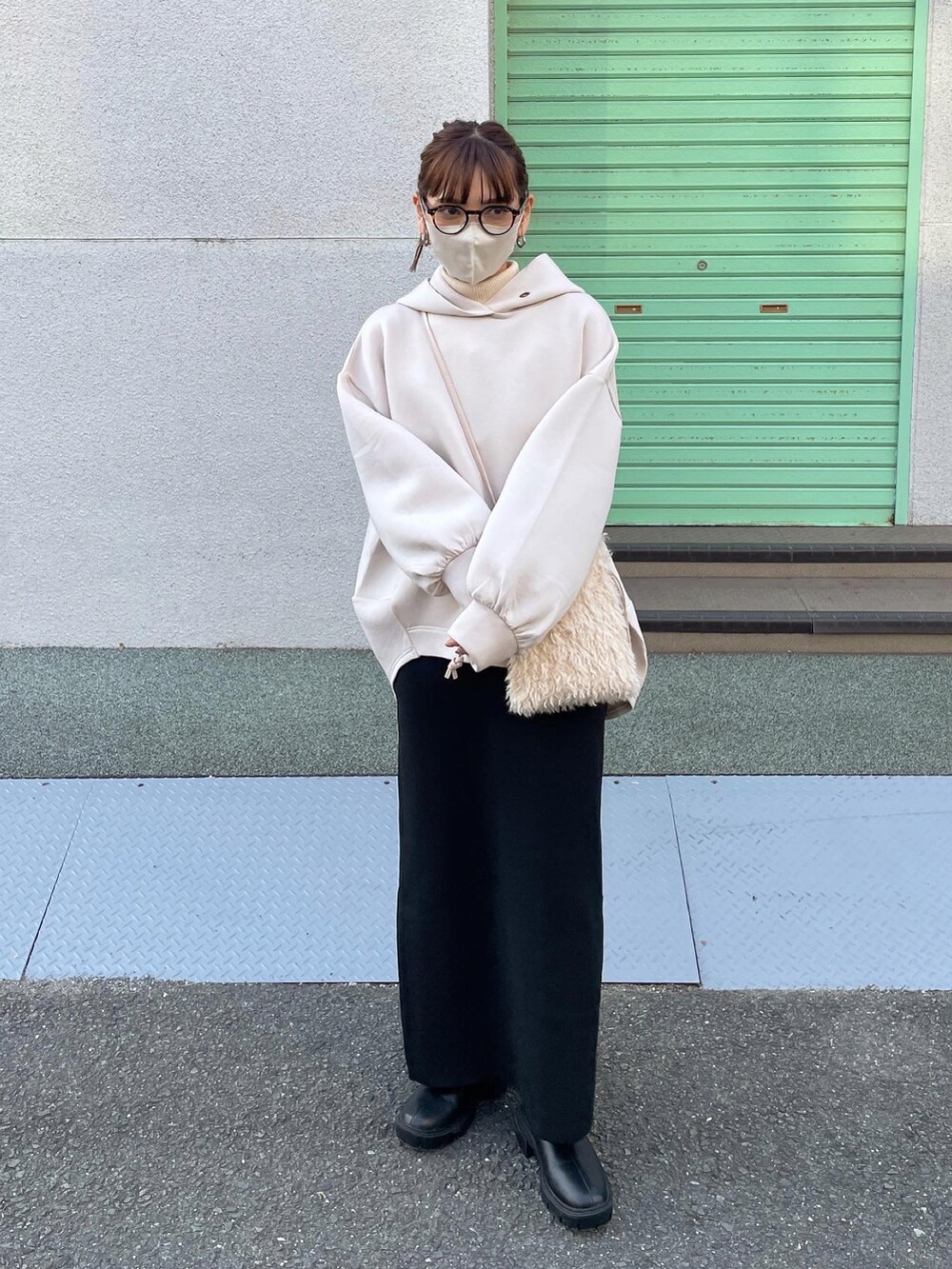 ベージュ系のパーカー、ブラック系のスカート、ホワイト系のショルダーバッグを着用したレディースの秋コーディネートの4枚目の写真