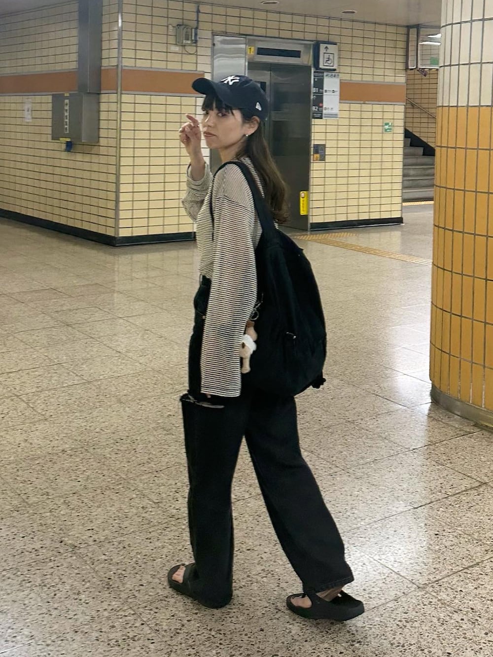 ブラック系のデニムパンツ、ホワイト系のTシャツ/カットソー、ブルー系のキャップを着用したレディースの春コーディネートの2枚目の写真