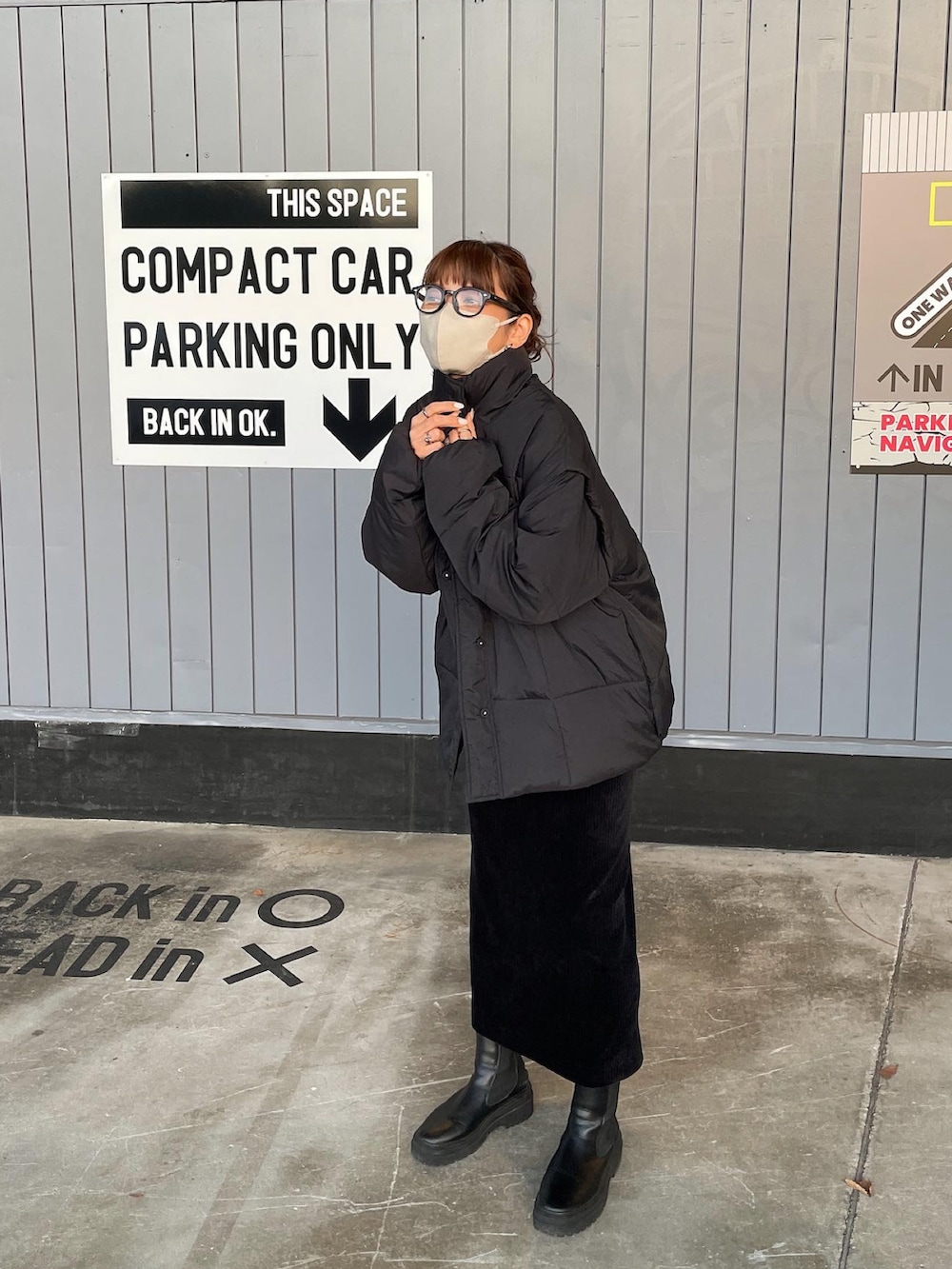 ブラック系のダウンジャケット/コート、ブラック系のスカート、ブラック系のブーツを着用したレディースの冬コーディネートの3枚目の写真