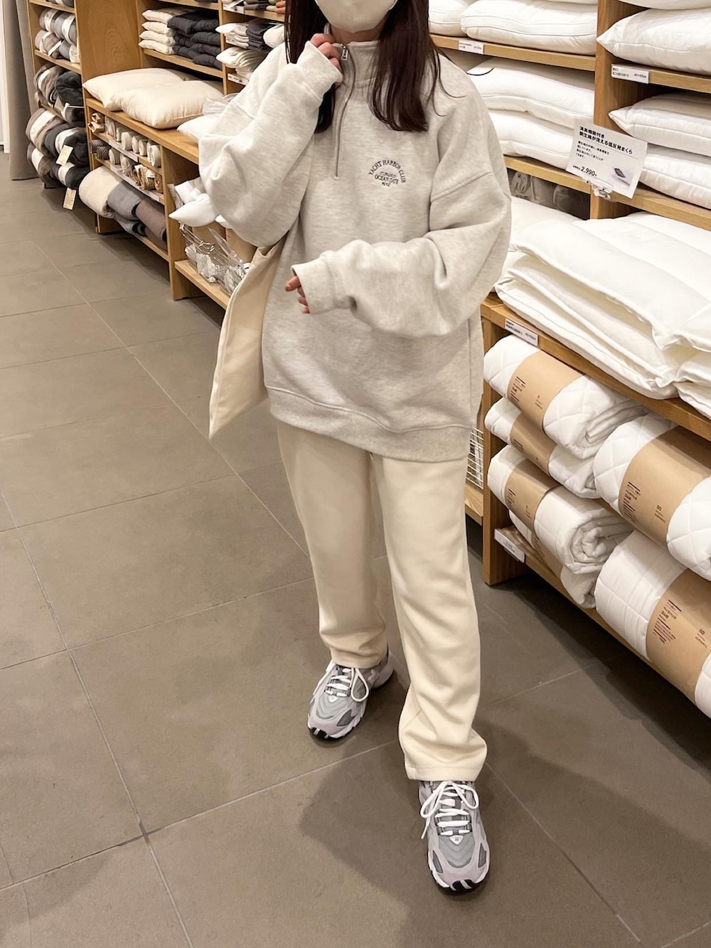 ベージュ系のスウェット、ホワイト系のパンツを着用したレディースの秋コーディネートの4枚目の写真