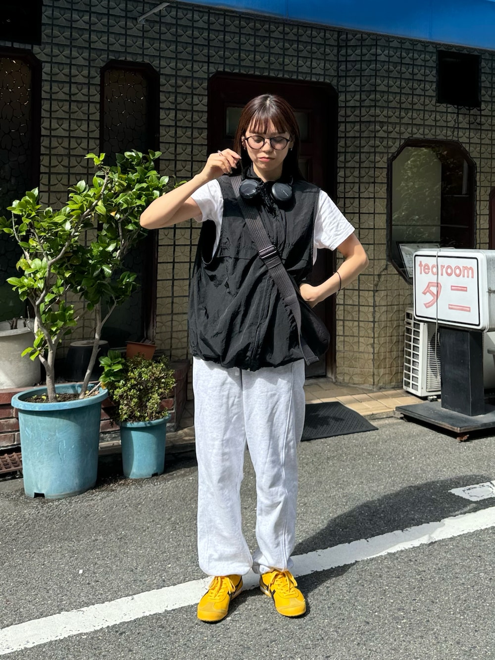 ブラック系のベスト、グレー系のスウェットパンツ、ブラック系のショルダーバッグを着用したレディースの秋コーディネートの2枚目の写真