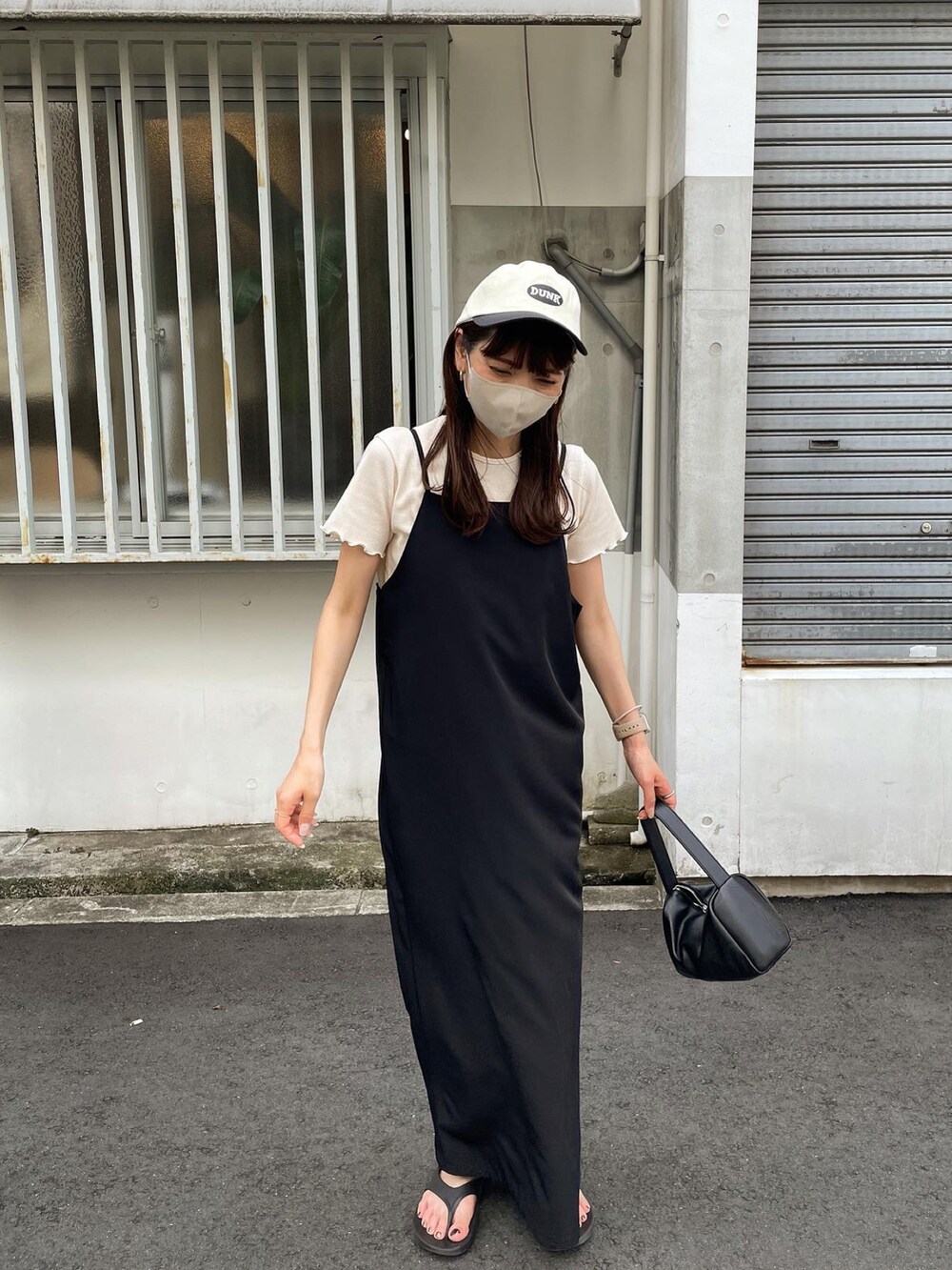 ホワイト系のTシャツ/カットソー、ブラック系のワンピース、ブラック系のサンダルを着用したレディースの夏コーディネートの2枚目の写真