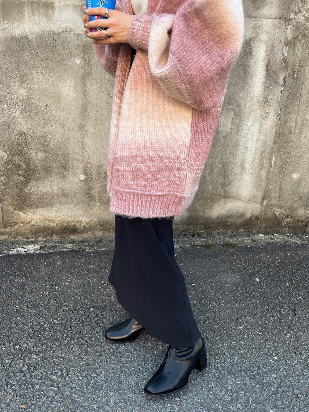 ピンク系のカーディガン/ボレロ、ブラック系のスカート、ホワイト系のキャミソールを着用したレディースの秋コーディネートの5枚目の写真