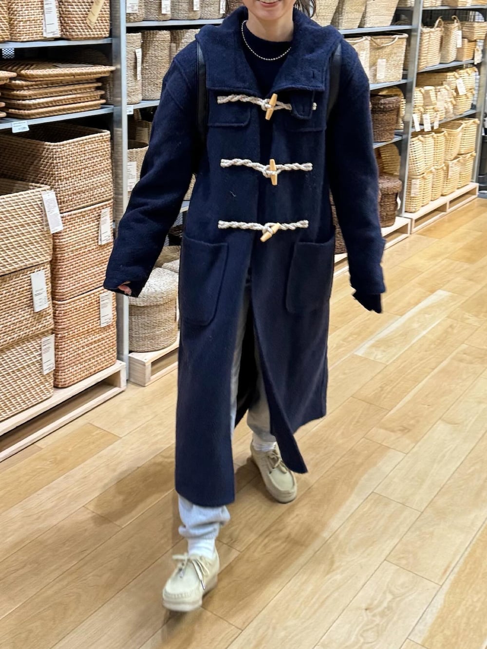 ブルー系のダッフルコート、ブルー系のニット/セーター、ベージュ系のモカシン/デッキシューズを着用したレディースの冬コーディネートの3枚目の写真