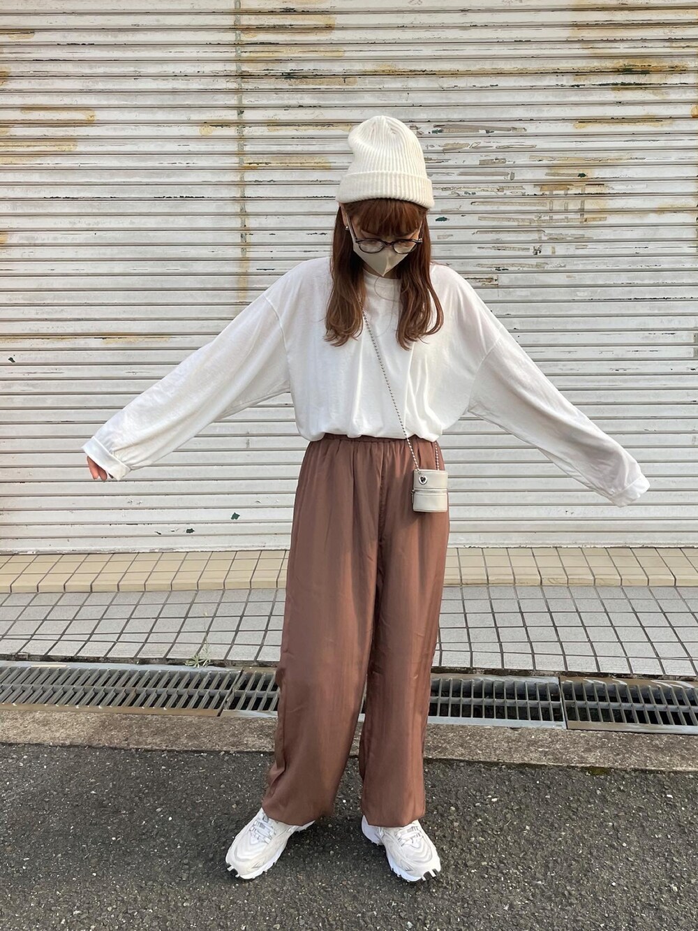 ブラウン系のその他パンツ、ホワイト系のショルダーバッグ、ベージュ系のスニーカーを着用したレディースの秋コーディネートの3枚目の写真