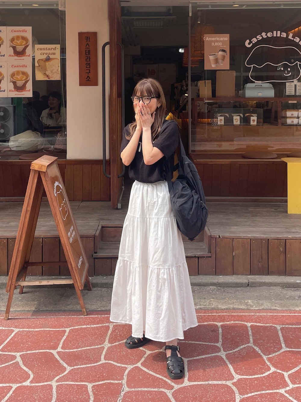 ホワイト系のスカート、ブラック系のその他シューズを着用したレディースの春コーディネートの3枚目の写真