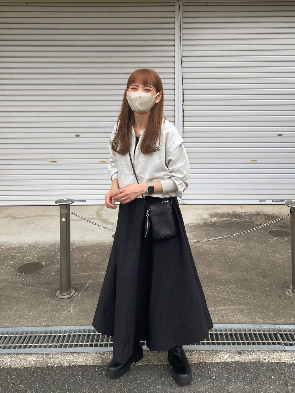 グレー系のワンピース、ブラック系のショルダーバッグ、ブラック系のブーツを着用したレディースの秋コーディネートの2枚目の写真