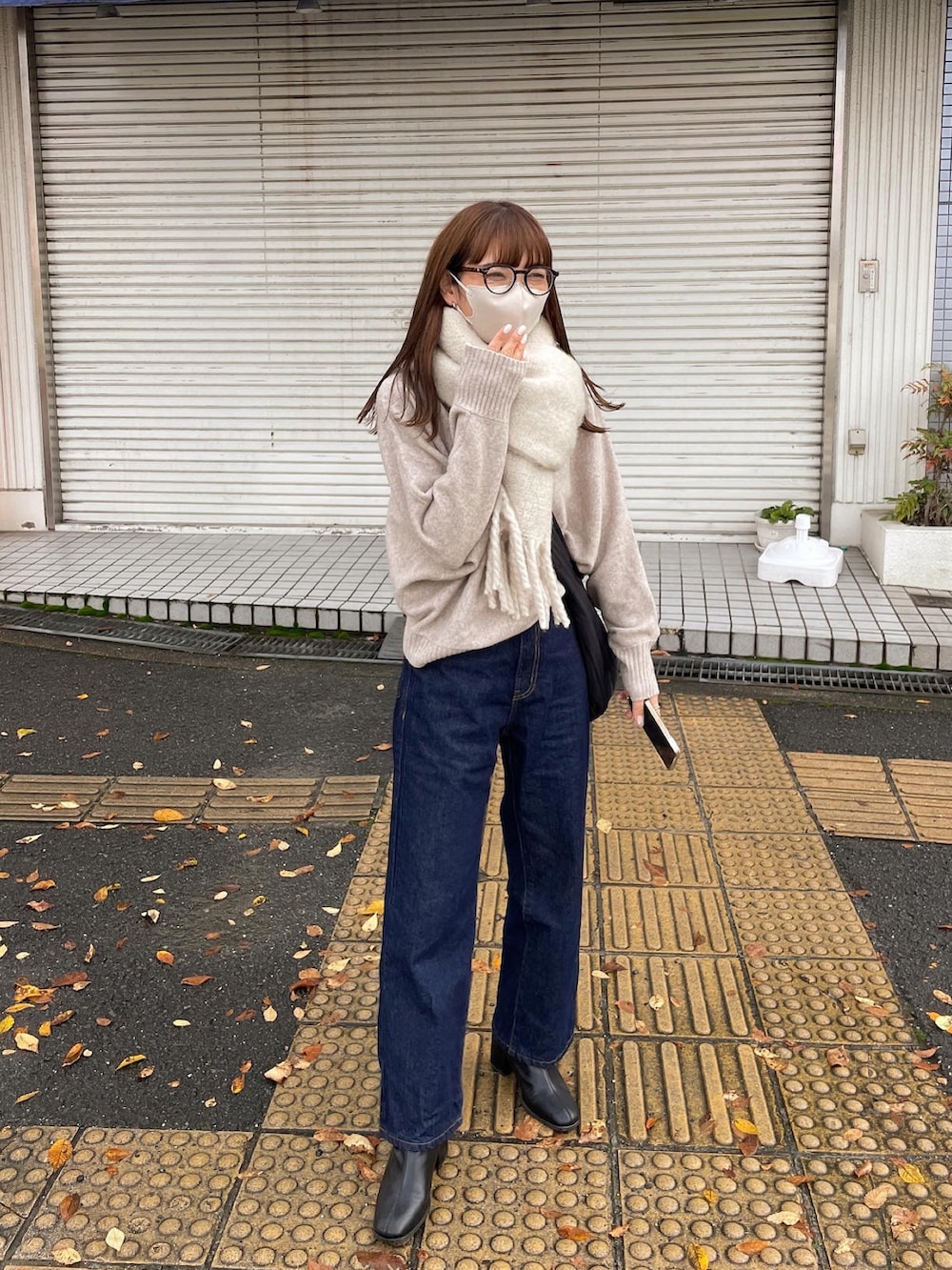 ベージュ系のニット/セーター、ブルー系のデニムパンツを着用したレディースの冬コーディネートの3枚目の写真