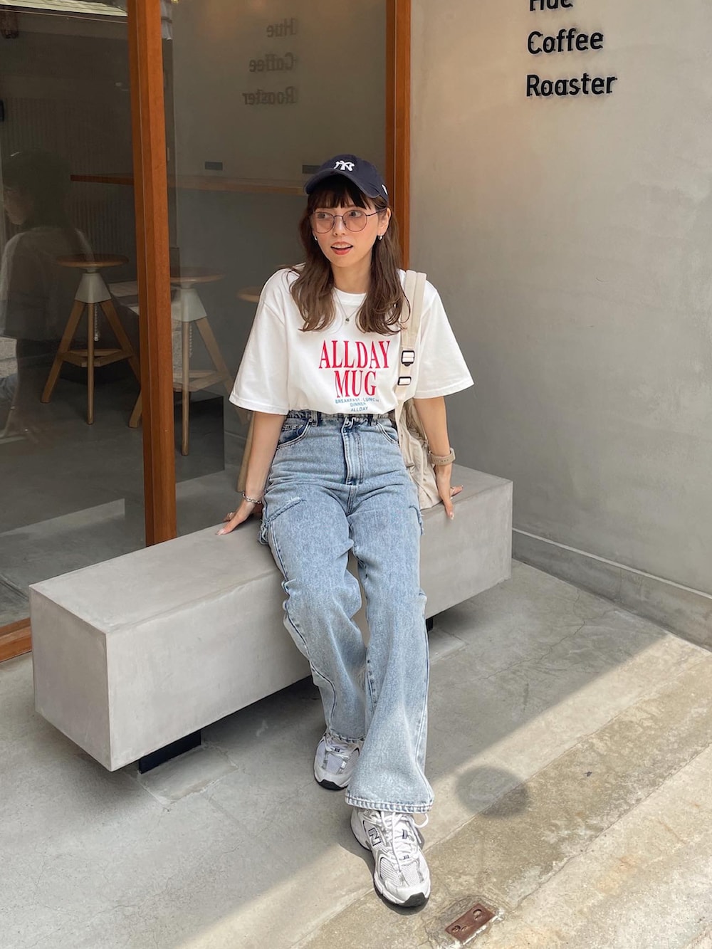 ホワイト系のTシャツ/カットソー、ブルー系のデニムパンツ、ブラック系のバックパック/リュックを着用したレディースの夏コーディネートの3枚目の写真