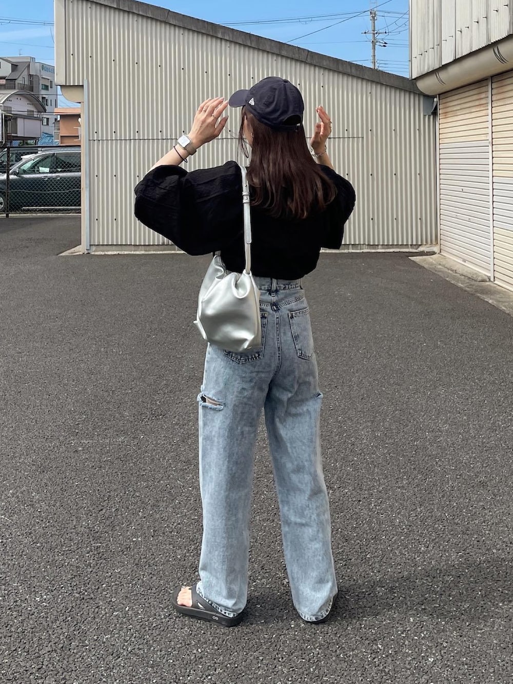 ブラック系のシャツ/ブラウス、ブルー系のデニムパンツ、シルバー系のショルダーバッグを着用したレディースの夏コーディネートの3枚目の写真