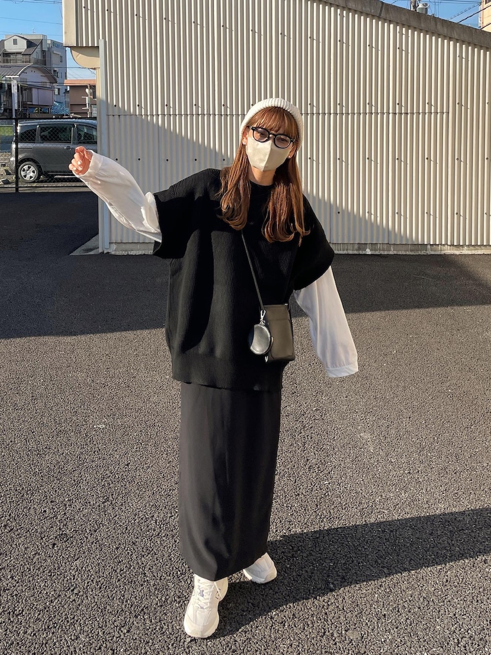 ブラック系のベスト、ホワイト系のTシャツ/カットソー、ブラック系のスカートを着用したレディースの秋コーディネートの4枚目の写真