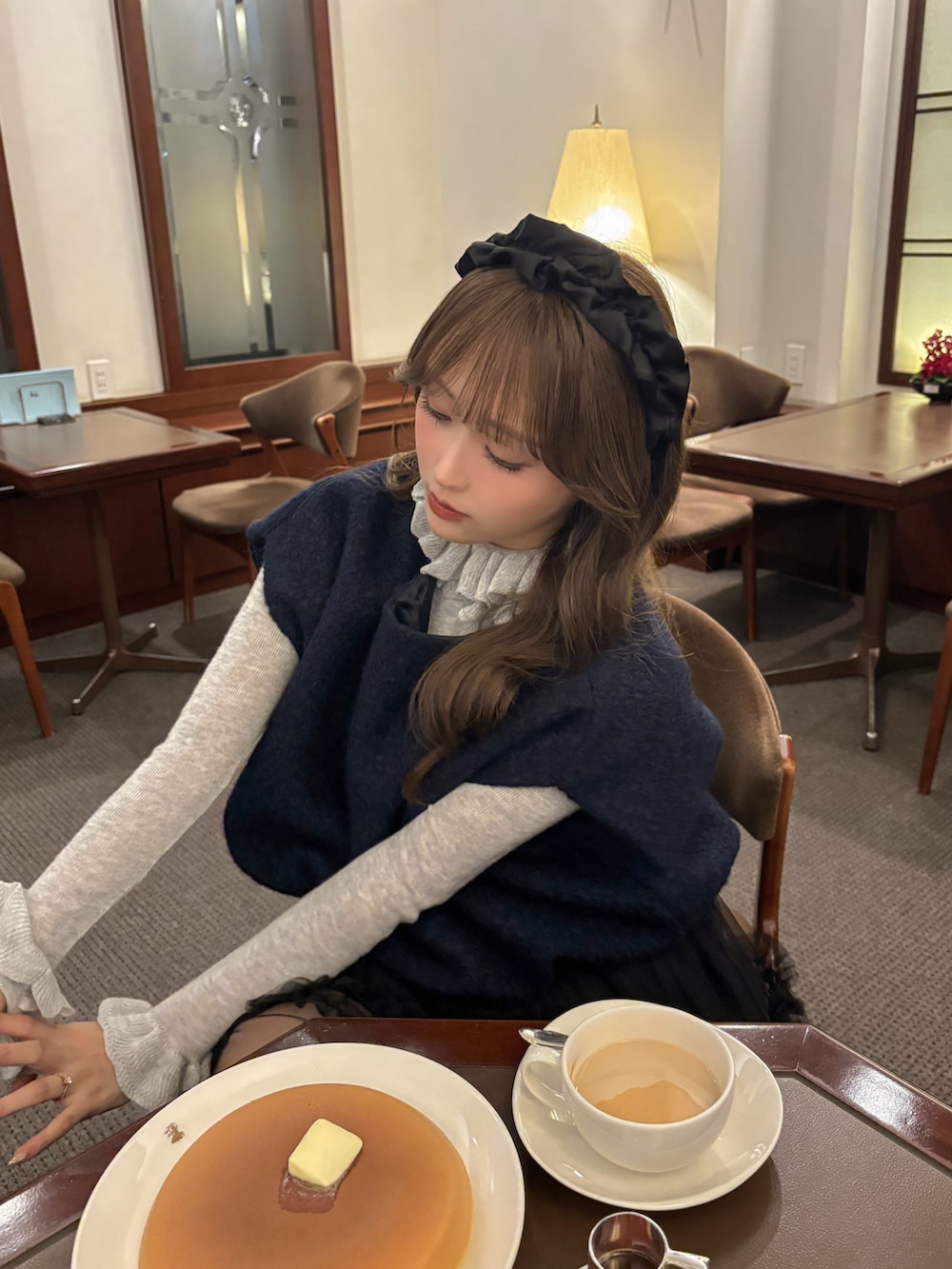 ブラック系のパンプス、ブルー系のトップス、ブラック系のスカートを着用したレディースの秋コーディネートの4枚目の写真