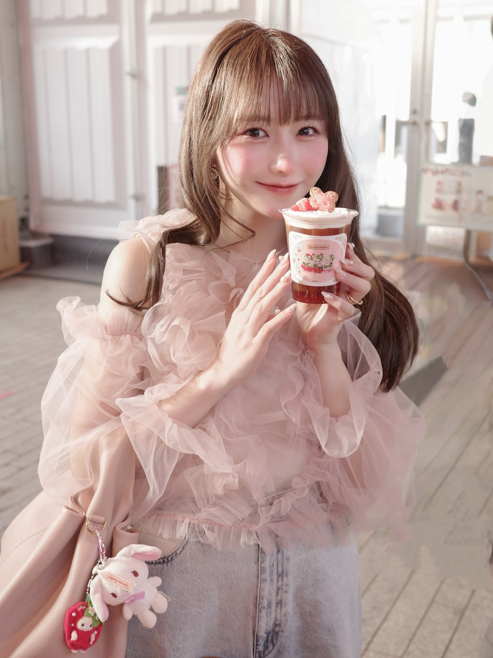 ブルー系のデニムパンツ、ピンク系のトップス、ピンク系のバッグを着用したレディースの冬コーディネートの2枚目の写真