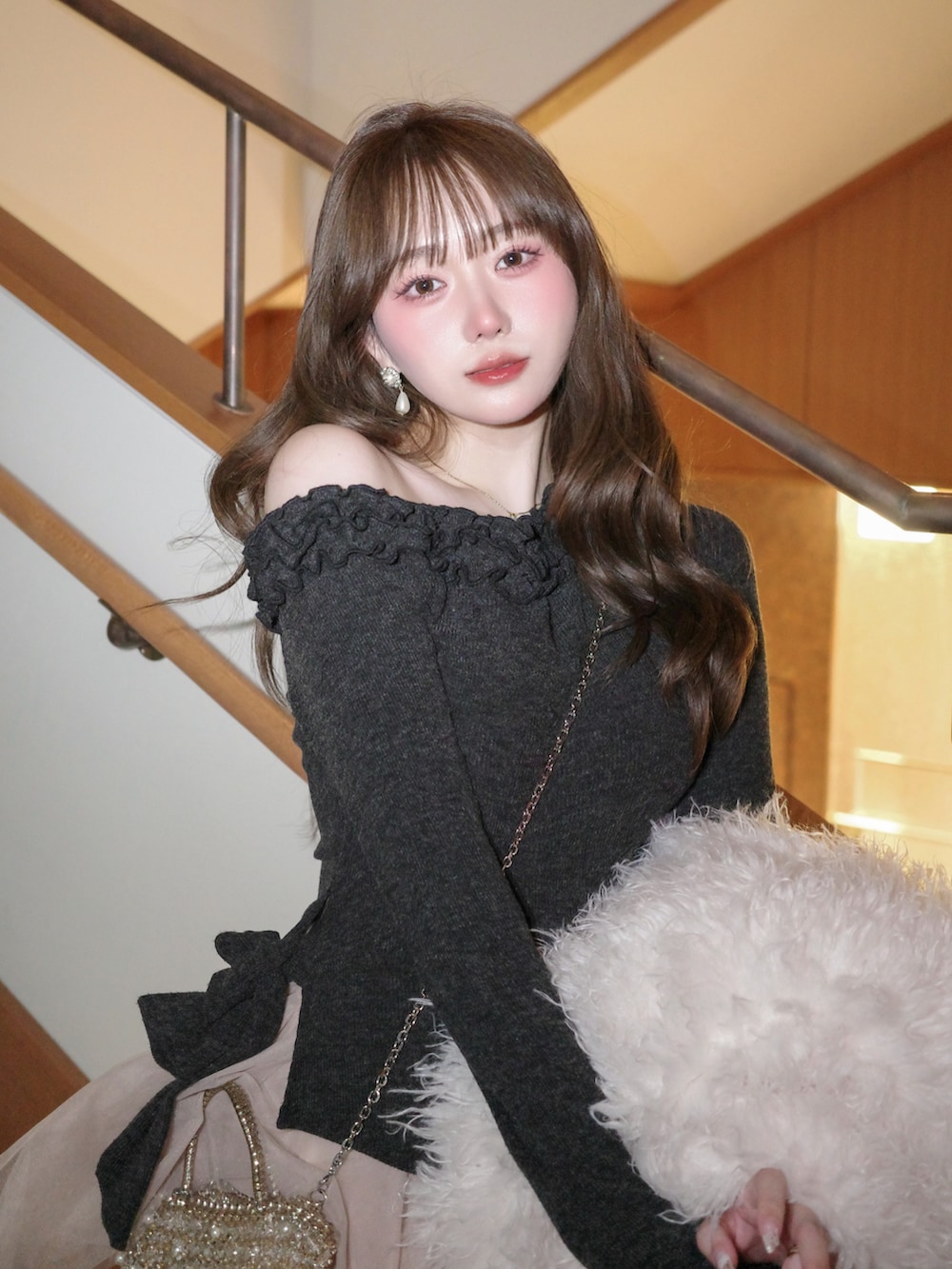 グレー系のシューズ、ピンク系のスカート、グレー系のセットアップを着用したレディースの冬コーディネートの5枚目の写真