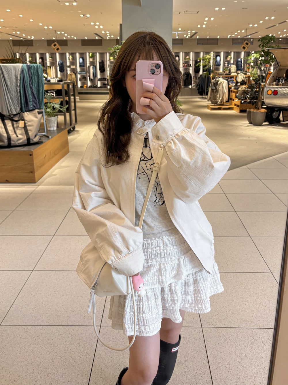 ブルー系のレインシューズ、ブルー系のシューズ、ベージュ系のショルダーバッグを着用したレディースの秋コーディネートの3枚目の写真