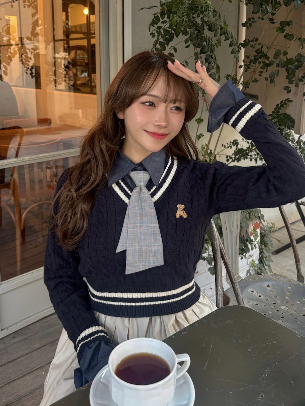 ブルー系のニット/セーター、ベージュ系のショルダーバッグ、ホワイト系のワンピースを着用したレディースの冬コーディネートの2枚目の写真