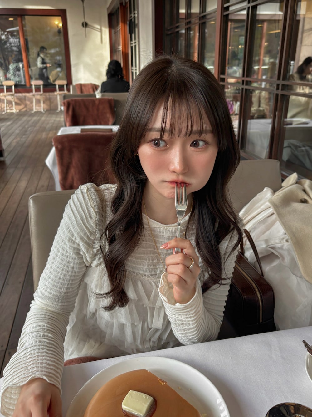 ホワイト系のTシャツ/カットソー、ホワイト系のトップス、ブラウン系のスカートを着用したレディースの冬コーディネートの4枚目の写真