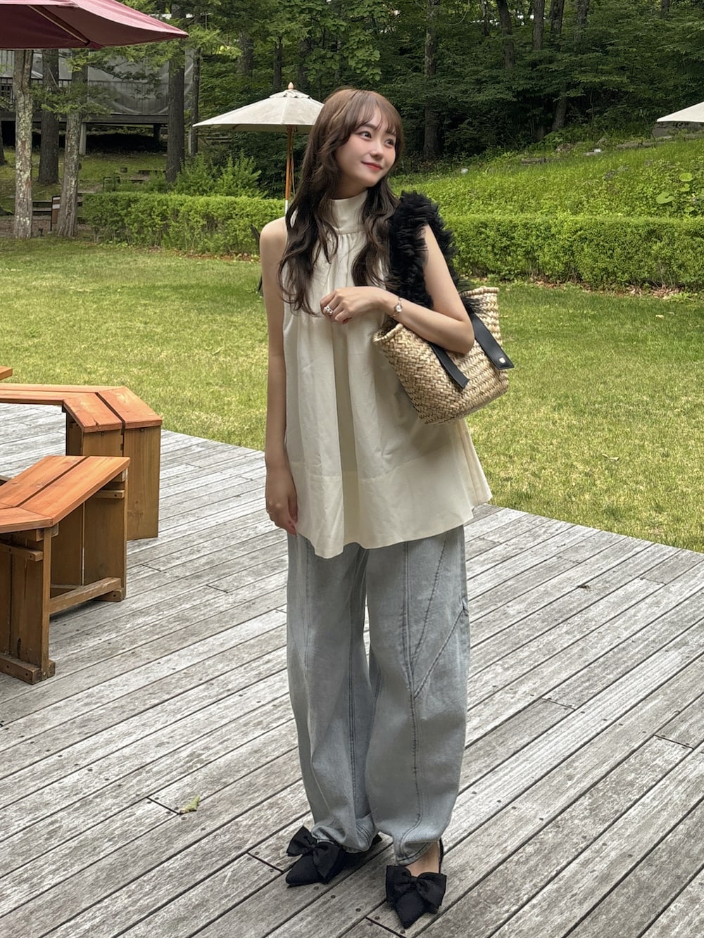 ブルー系のデニムパンツ、ホワイト系のシャツ/ブラウス、ブラック系のかごバッグを着用したレディースの夏コーディネートの3枚目の写真