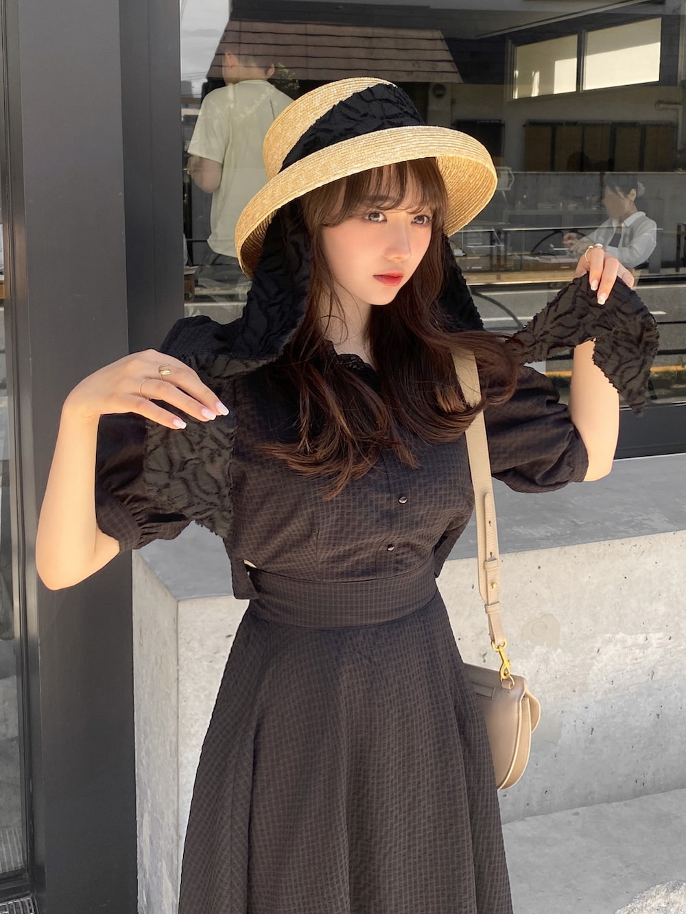ベージュ系のバッグ、ホワイト系のサンダル、ブラック系のワンピースを着用したレディースの夏コーディネートの5枚目の写真