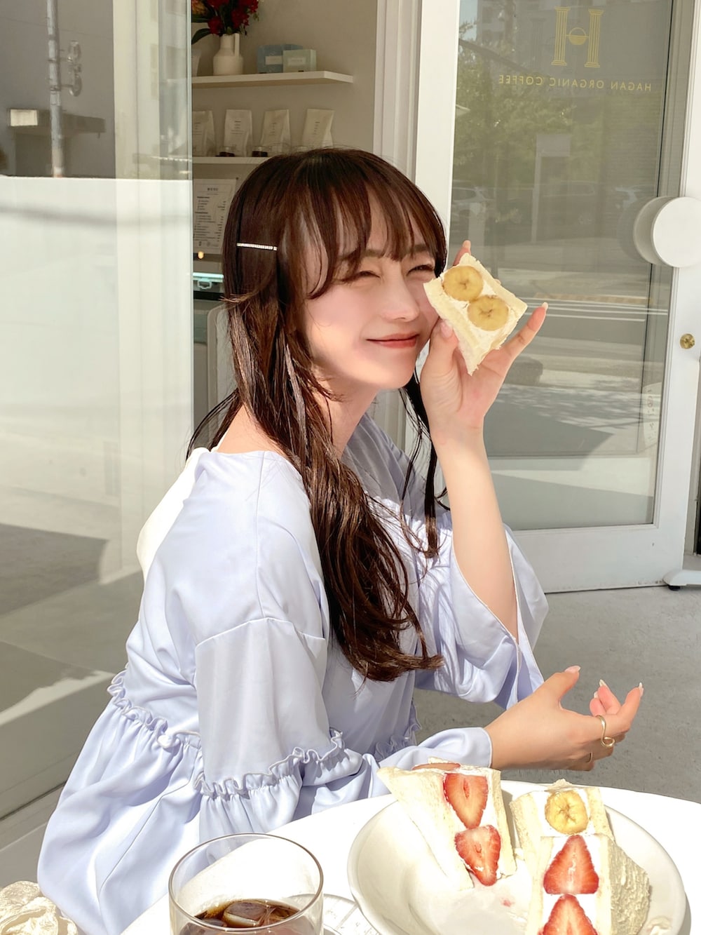 ブルー系のワンピース、ホワイト系のハンドバッグ、ホワイト系のその他パンツを着用したレディースの春コーディネートの2枚目の写真