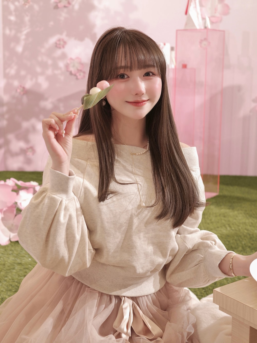 ピンク系のスカート、ベージュ系のスウェット、ホワイト系のバッグを着用したレディースの冬コーディネートの3枚目の写真