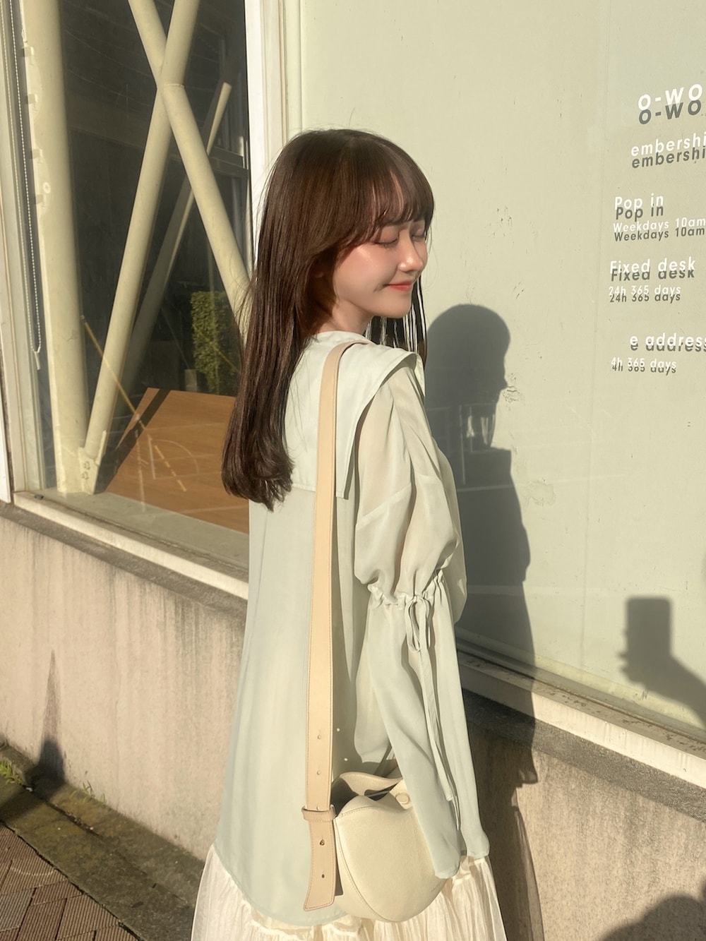 ベージュ系のスカート、ホワイト系のショルダーバッグ、ホワイト系のサンダルを着用したレディースの夏コーディネートの5枚目の写真